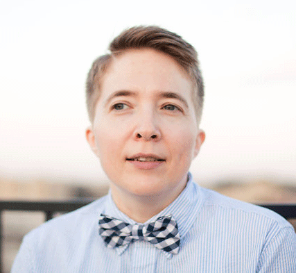 Head shot photo of a person with short hair wearing a button down shirt and a bowtie.